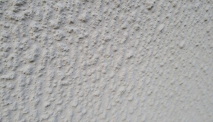 Close-up texture of a light gray wall with a unique, slightly rough surface. The pattern shows subtle diagonal lines created by the wall's texture.