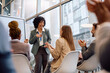 © Drazen - Happy business seminar speaker receiving applause from her colleagues in board room.