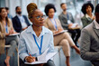 © Drazen - Young black businesswoman taking notes while attending education event in board room.