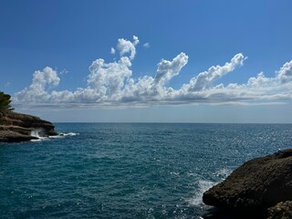 Poster - Amazing clouds over blue shiny sea and rocky coast.