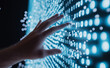 © Curioso.Photography - A hand reaches towards a glowing wall of binary code, symbolizing technology interaction and digital innovation.
