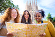 © CarlosBarquero - Young only women friend looking travel map in hands in front of Sagrada Familia in Barcelona. Beautiful mixed race girl at European city enjoying vacation happy and smiling. Funny tourism smile people