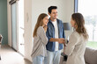 © fizkes - Happy young couple of buyers or renters shaking hands with real estate insurance agent, standing inside new house, giving handshake to realtor, property seller, smiling, closing deal