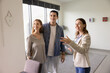 © fizkes - Happy realtor woman showing apartment to positive young couple of renters. Real estate agent and buyers meeting in house or flat, looking at interior, discussing buying, mortgage