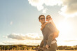 © kieferpix - father and son in the park. father's day happy family child dream concept. father carries his son on his back. dad playing with his son in nature in the park at sunset lifestyle