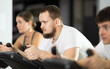 © JackF - Motivated man works out on an exercise bike during a group workout in the gym. European at cardio training in a fitness club