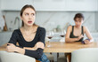 © JackF - Upset middle-aged woman sitting at the kitchen table with her back to another lady quarreling angrily to her