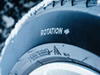 © ifeelstock - Close-up of a winter tire showing the Rotation indicator and a snowflake symbol, partially covered with frost, highlighting directional tire alignment.