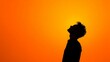 © Lush Diaries - Silhouette of a young man looking up at a vibrant orange sky.
