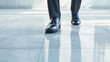 © Tossakan Photos - Close-up of a businessperson’s polished shoes walking on a marble floor with a shadowy reflection, symbolizing professionalism, elegance, and purpose.