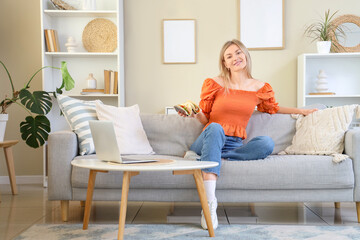 Sticker - Young woman with tasty tacos sitting on sofa at home