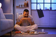 © Pixel-Shot - Hungry young man eating different food near open refrigerator in kitchen at night