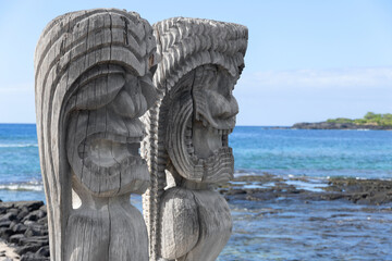 Wooden carved statues of Hawaiian gods, Protectors ki'i, at the shore of Pacific ocean. Puʻuhonua o Hōnaunau national historical park, Hawaii, the USA.