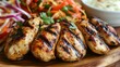 © Plaifah - Detailed shot of succulent grilled chicken pieces served alongside a tangy and spicy papaya salad, highlighting the fresh ingredients and appetizing presentation.