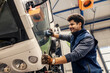 © Dusan Petkovic - Hardworking multicultural serviceman cleaning truck in garage.