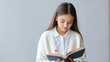 © David - Young girl in white cardigan reading opened book. Copy space. lifestyle and school concept. Banner