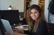 © Khawla - Busy young business woman executive using laptop in office. Smiling businesswoman company employee sitting at work desk, professional female hr manager looking at pc computer at workplace