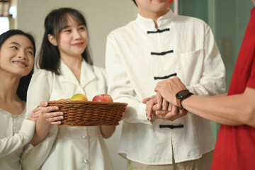 Cheerful family arriving at door with basket of fresh fruits symbolizing of goodwill and blessings during Chinese New Year