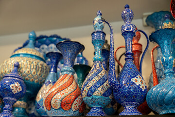 A collection of blue and red vases are displayed on a shelf. The vases are of different shapes and sizes, and they are arranged in a way that creates a visually appealing display