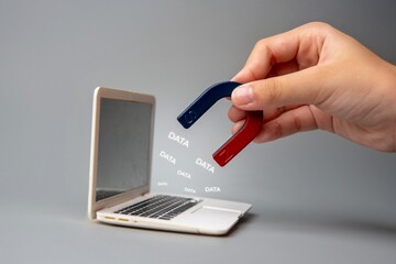Wall Mural - a hand holding a magnet near a laptop screen with the word 