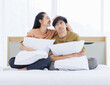 © Bangkok Click Studio - Portrait of young lovely sweet attractive asian happy couple love posing to camera smiling hugging pillow sitting on white bed in bedroom at home good time romantic together Valentine's day concept.