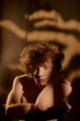 © AnnaStills - Vertical portrait of young adult cure red haired man sitting and posing for portrait in studio