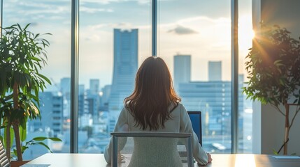 Poster - A cute Japanese women office worker sitting at a modern, sleek desk in a clean and spacious high-rise office. The office features minimalist elegant interior design.