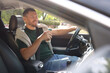 © New Africa - Man with cup of coffee driving modern car