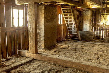 Wall Mural - Old rustic wooden barn, picturesque vintage with hay and boards, flooded with the evening summer sun