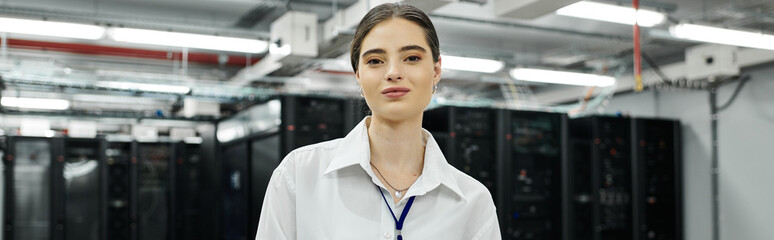 A woman in a white shirt works confidently in a high-tech server room, managing systems, banner