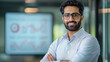 © PRASANNAPIX - A confident Indian handsome businessman standing in front of a large digital presentation screen, analyzing financial data and growth charts.