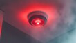 © DNY3D - Close-up of a functional, ceiling-mounted smoke alarm with a bright, pulsating red led warning light indicator
