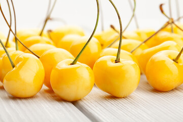 Wall Mural - yellow cherry on white wood background