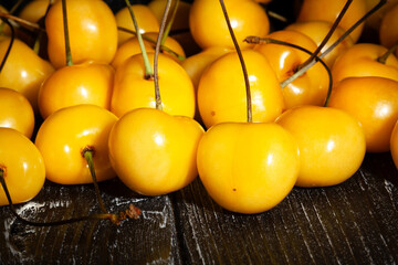 Wall Mural - yellow cherry on black wood background