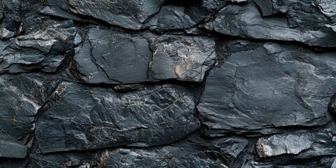 Wall Mural - Dark grey and black slate stone texture with irregular shapes and rough surfaces creating a rugged backdrop ideal for design and photography.