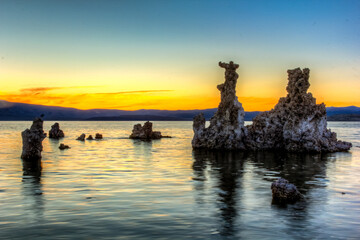 Wall Mural - A beautiful sunset over a body of water with a rocky shoreline