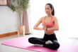 © N_studio - Young asian woman meditation sitting on mat in serene and tranquility with yoga in living room at home, woman practice yoga with breathing balance for mindfulness, sport and wellness for care.