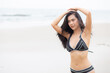 © NT_studio - Beautiful young asian woman standing with happiness for relax on beach in tropical, happy woman in bikini with expression relaxation in holiday with seductive, recreation and leisure in summer.