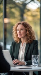 Aufkleber - Middle-aged businesswoman engaged in discussion at modern office with glass walls and natural light