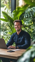 Aufkleber - Cheerful man working on laptop in a lush green indoor environment during the day