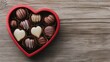 © Arfa_Media - Heart-shaped box filled with assorted chocolates lying on wooden table