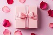 © Arfa_Media - Pink gift box with satin ribbon bow and rose petals scattered on pastel pink background
