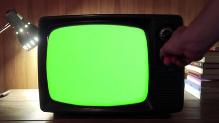 Wall Mural - hand switching on green-screen television - close up - zoom in - 100% real video, not ai generated -