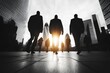 © Vertigo Images - Silhouetted businesspeople walk towards the sun in a city.  A powerful image of ambition and success.