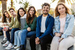 © Xavier Lorenzo - Group of young multiracial people enjoying time together sitting on a low wall in the city. Youth community and friendship concept