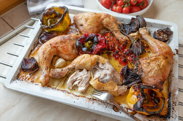 Wall Mural - Roasted chicken legs with oven vegetables on a baking tray fresh and homemade cooked