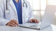 © Noppakun - Healthcare Professional Engaged with Laptop in Modern Medical Office Setting, Demonstrating Technology Use in Patient Care and Documentation Management