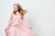 © SHOTPRIME STUDIO - Joyful girl in a pink dress, twirling in motion, showcasing happiness, innocence, and playful spirit against a light background