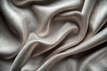 Soft silver fabric draping elegantly across a surface for textile design