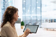 © DC Studio - Businesswoman evaluating the real estate potential on an office tour, examining detailed blueprints on a tablet for workspace relocation. Entrepreneur planning to make a reliable investment.